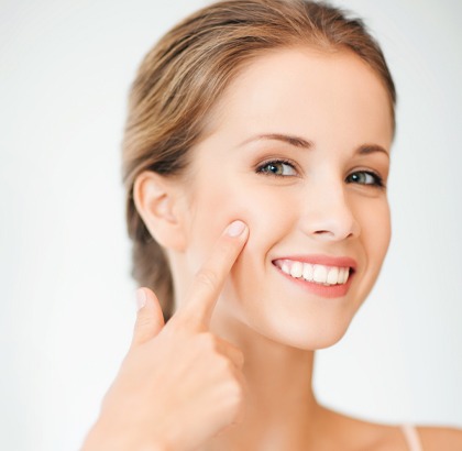 Woman pointing to cheek without wrinkles, smiling